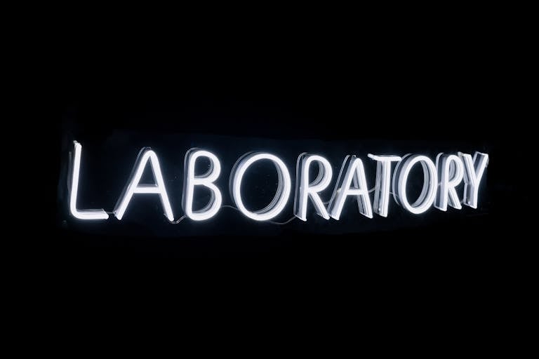Bright neon sign displaying the word 'Laboratory' on a black background, perfect for science themes.