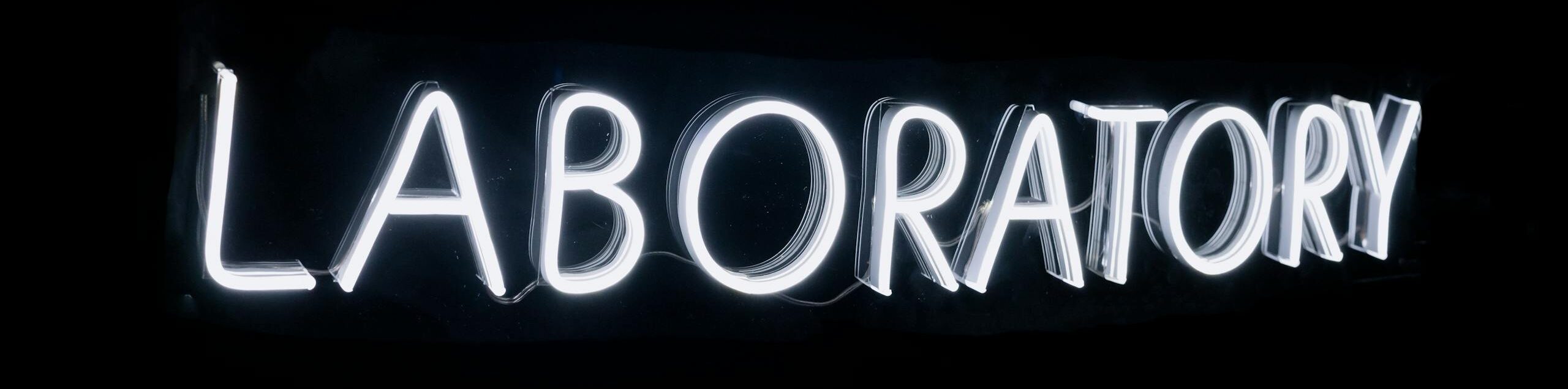 Bright neon sign displaying the word 'Laboratory' on a black background, perfect for science themes.