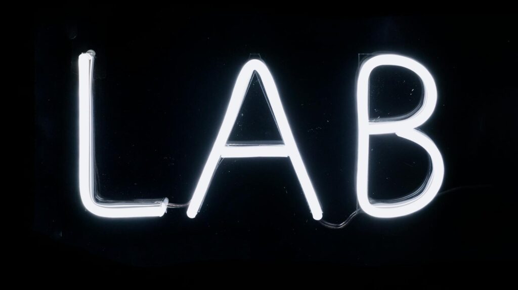 Bright neon LAB sign glowing against a dark background, perfect for scientific themes.